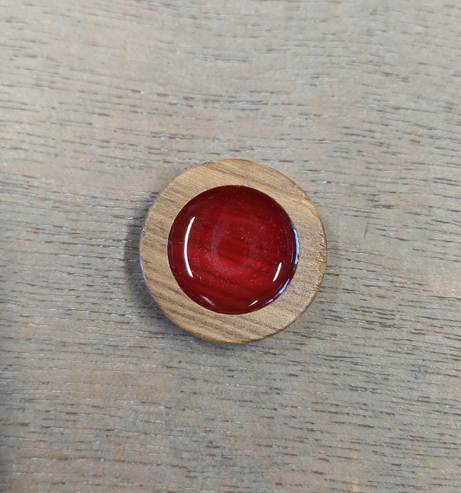 Puunappi kiiltävällä keskuksella Punainen